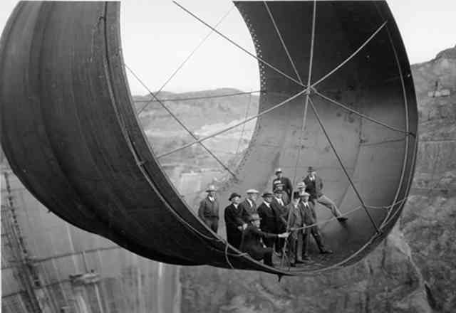 34. Men stand in a 45,000-ton steel pipe over the Hoover Dam.